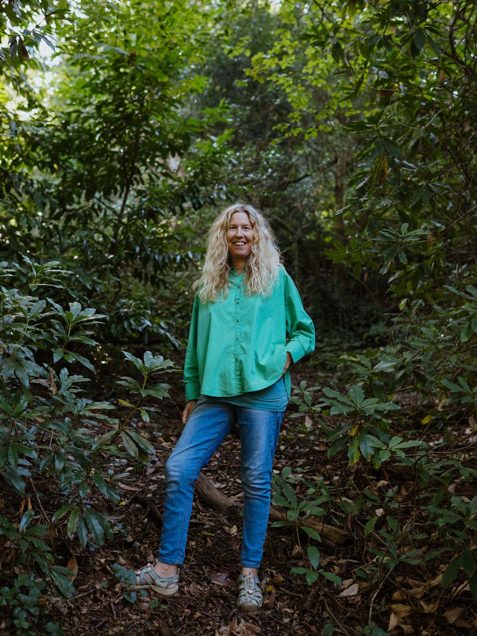 Anne-Marie standing on a woodland path among rhododendrons